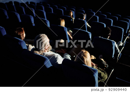 High angle view of unrecognizable people sitting in in darkness in cinema hall waiting for movie to start 92909440