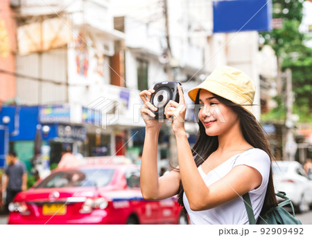 Asian Traveler woman with instant camera at Khaosan 92909492