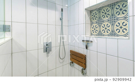 Panorama Shower stall interior with white ceramic tiles surround and cement tiles with blue patterns Panorama Shower stall interior with white ceramic tiles surround and cement tiles with blue patterns 92909942