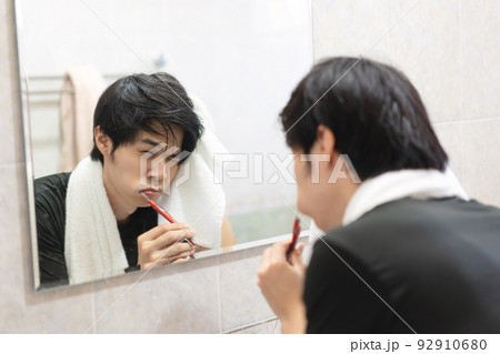 Adult asian man toothbrush in front of mirror toothache from decayed. 92910680