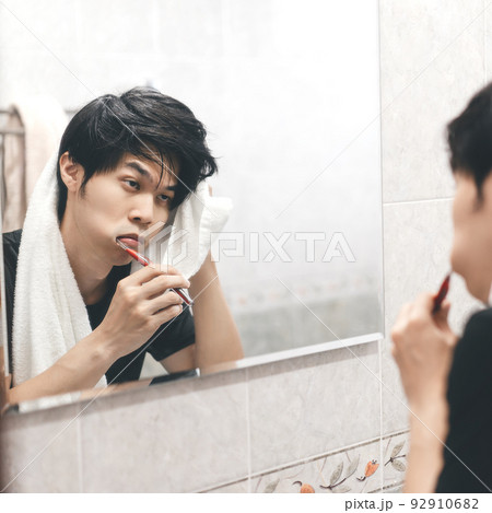 Adult asian man toothbrush in front of mirror toothache and tried. Adult asian man toothbrush in front of mirror toothache and tried. 92910682