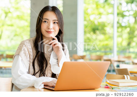 キャンパスでパソコンを使う大学生の女の子 92912260
