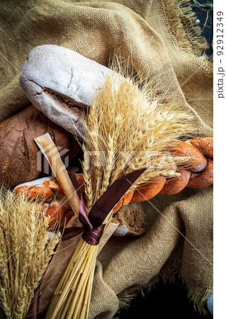 Top view of a bouquet of wheat lying on fresh bread and other bakery products as a symbol of food and agrarian well-being of the country 92912349