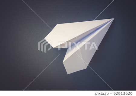 White paper plane origami isolated on a grey background 92913620