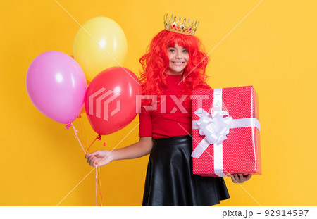 glad kid in crown with present box and party balloon on yellow background glad kid in crown with present box and party balloon on yellow background 92914597