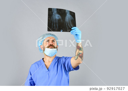 Surgery operation and medical concept. man look at roentgen. Radiologist hold xray. doctor examines radiographical snapshot. x-raying of hands. nurse checking x-ray film at hospital. health problems 92917027
