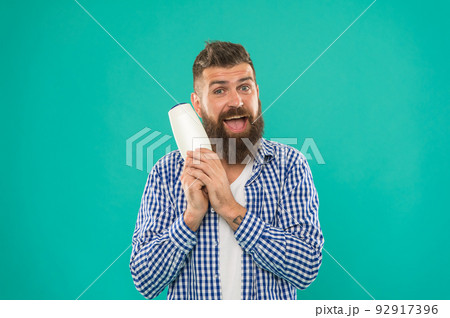 Barbershop and hair care. Shampoo review concept. Test beauty product. Launching beauty product. Hair conditioner or lotion. Man bearded hipster hold bottle shampoo or shower gel. Hair care treatment 92917396