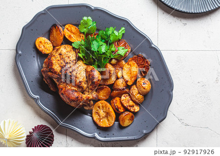 Christmas baked chicken with potatoes on gray plate. Festive homemade food concept. 92917926