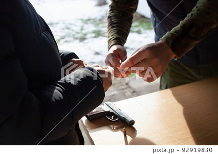 A man charges a gun with bullets in the street. Danger, murder, firearms, shooting range, sports entertainment. A man charges a gun with bullets in the street. Danger, murder, firearms, shooting range, sports entertainment. 92919830