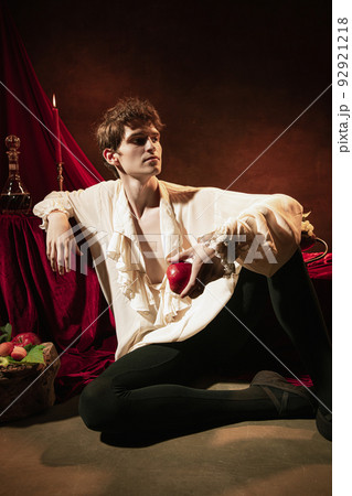 Colorful fictional portrait of young adorable man in image of famous historical character, medieval person isolated on dark vintage background. Retro style 92921218