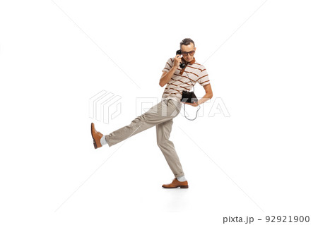 Portrait of stylish businessman in retro clothes talking on vintage phone isolated over white background 92921900