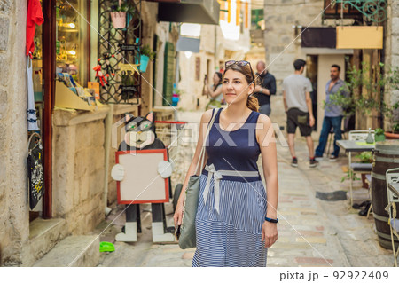 Woman tourist enjoying Colorful street in Old town of Kotor on a sunny day, Montenegro. Travel to Montenegro concept Portrait of a disgruntled girl sitting at a cafe table Woman tourist enjoying Colorful street in Old town of Kotor on a sunny day, Montenegro. Travel to Montenegro concept Portrait of a disgruntled girl sitting at a cafe table 92922409