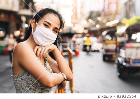 Happy asian adult woman tan skin wear mask on face for new normal. Happy asian adult woman tan skin wear mask on face for new normal. 92922554