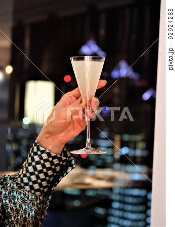 三角グラスに入った白いカクテルで乾杯 三角グラスに入った白いカクテルで乾杯 92924283