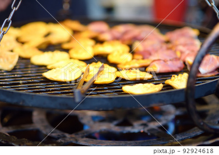 Traditional Poland street food oscypek is a grilled cheese of salted sheep milk with different ingredients as bacon or jams. Cooking of oscypek on Christmas market in Krakow. 92924618