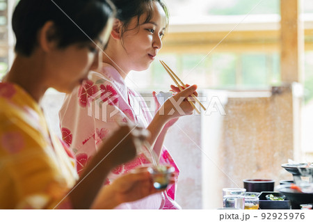 旅行先の部屋でご飯を食べる浴衣姿の女性 92925976