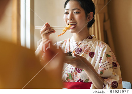 旅行先の部屋でご飯を食べる浴衣姿の女性 旅行先の部屋でご飯を食べる浴衣姿の女性 92925977
