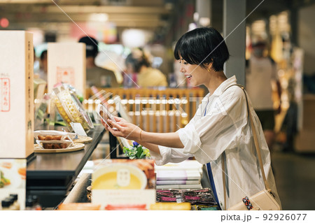 旅先でお土産を買う女性 92926077
