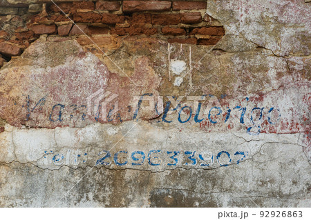 Erased handwritten inscription over the entrance to the ruined building 92926863