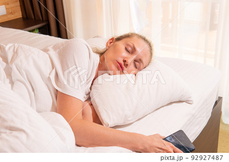 Woman phone beautiful sleep blonde mobile bed blanket eyes morning, for white relax in people and home rest, comfortable healthy. Relaxation cozy relaxing, lie Woman phone beautiful sleep blonde mobile bed blanket eyes morning, for white relax in people and home rest, comfortable healthy. Relaxation cozy relaxing, lie 92927487