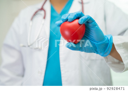 Doctor holding a red heart in hospital ward, healthy strong medical concept. Doctor holding a red heart in hospital ward, healthy strong medical concept. 92928471