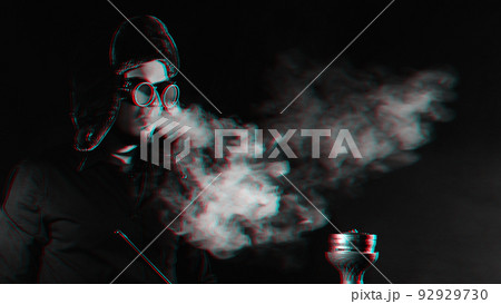 bearded man smokes a shisha in a hookah bar and blows a cloud of smoke 92929730