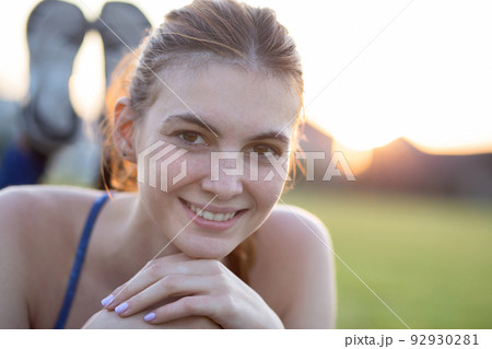 Close up portrait of cheerful smiling young girl with freckles on her face outdoors in sunny summer day. Human expressions and emotions concept. 92930281