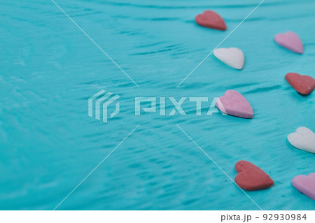 Close up colored candy hearts and copy space. Blue relief background. 92930984