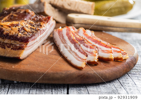 Sliced smoked bacon on cutting board. Sliced smoked bacon on cutting board. 92931909