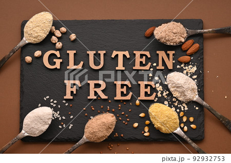 Gluten free text and spoons of various gluten free flour, almond, buckwheat, rice, corn, oat, chickpea. Flat lay, top Gluten free text and spoons of various gluten free flour, almond, buckwheat, rice, corn, oat, chickpea. Flat lay, top 92932753