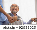 Close up.Asian nurse holding an elderly man with a walking stick for physiotherapy. 92936025