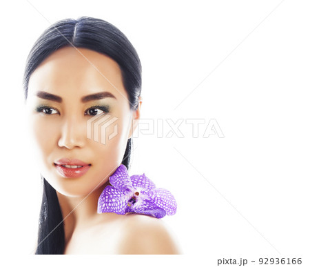 young pretty asian woman with flower purple orchid close up isolated on white background spa smiling casual 92936166