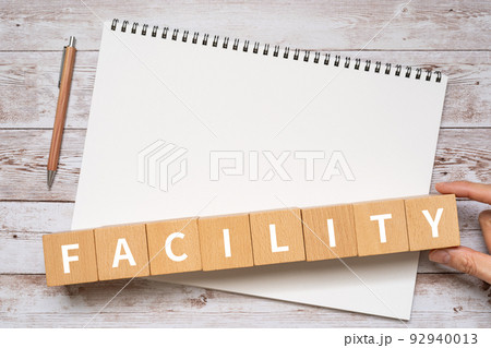設備・施設のイメージ|「FACILITY」と書かれたブロック、ノート、ペン、手 設備・施設のイメージ|「FACILITY」と書かれたブロック、ノート、ペン、手 92940013