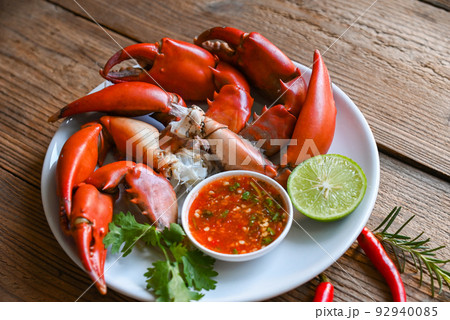 Fresh crab on white plate seafood sauce, boiled or steamed crab red in the restaurant, claw crab cooking food seafood plate with chili herbs spices lemon lime salad Fresh crab on white plate seafood sauce, boiled or steamed crab red in the restaurant, claw crab cooking food seafood plate with chili herbs spices lemon lime salad 92940085