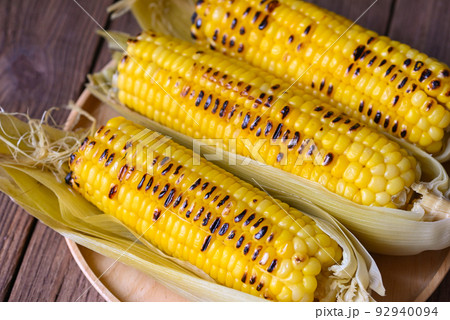 corn food , sweet corn cooked on wooden plate background, ripe corn cobs grilled sweetcorn for food vegan dinner or snack - top view corn food , sweet corn cooked on wooden plate background, ripe corn cobs grilled sweetcorn for food vegan dinner or snack - top view 92940094