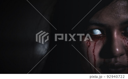 Close up of horror bloodthirsty ghost female with fade drop out from eyes Close up of horror bloodthirsty ghost female with fade drop out from eyes 92940722