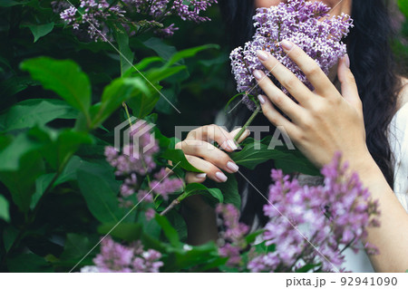 Hands of an attractive woman with a bouquet of lilacs. Spring and summer, seasonal photos. Front view. Hands of an attractive woman with a bouquet of lilacs. Spring and summer, seasonal photos. Front view. 92941090