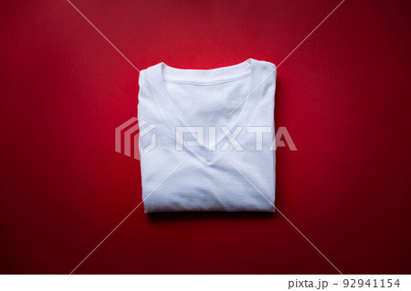【日本】赤い背景の上に置かれた四角く畳まれた白い綿シャツ 92941154