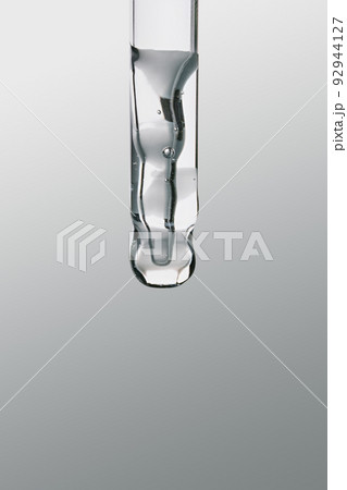 Pipette with gel cosmetic product on grey background, selective focus Pipette with gel cosmetic product on grey background, selective focus 92944127
