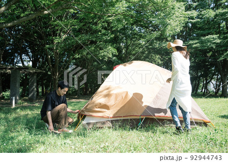 テントの設営をするカップル・キャンプ・アウトドアレジャー 92944743