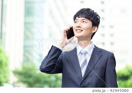ビジネス　スマホを持ち外を歩く男性 92945060