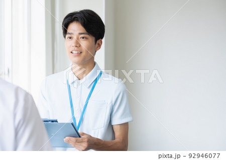 申し送りをするユニフォーム姿の男性 92946077