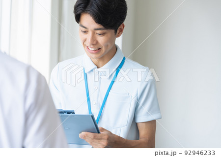 笑顔でメモをするユニフォーム姿の男性 笑顔でメモをするユニフォーム姿の男性 92946233