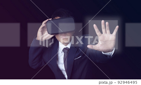 Man wearing VR Headset touching on a touch screen interface on neon color background. Man wearing VR Headset touching on a touch screen interface on neon color background. 92946495