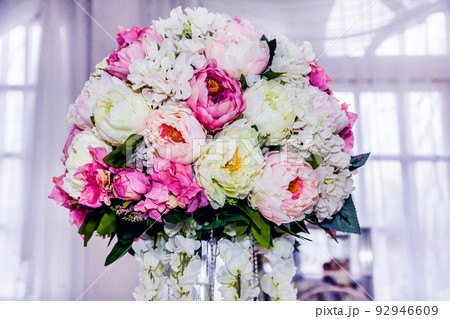 Flower arrangement at a wedding banquet in a restaurant in neon colors Flower arrangement at a wedding banquet in a restaurant in neon colors 92946609