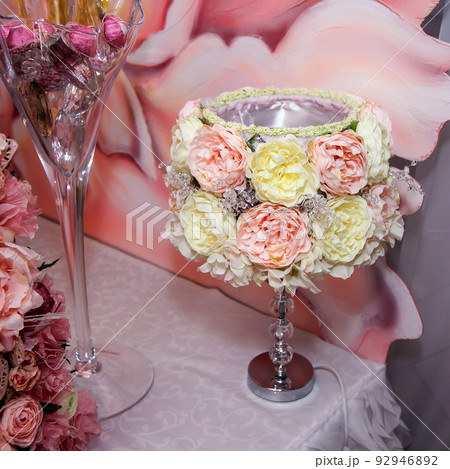 A lamp with a shade of artificial flowers on a dessert buffet table at a wedding banquet A lamp with a shade of artificial flowers on a dessert buffet table at a wedding banquet 92946892
