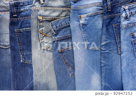 Heap of torn jeans denim background texture. Blue jeans fabric material surface Heap of torn jeans denim background texture. Blue jeans fabric material surface 92947152