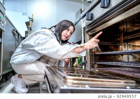 厨房を確認する若い女性のイメージカット　ガスオーブン 92949557