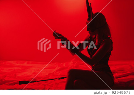 submissive sexy girl in underwear and a bunny mask sitting on the bed puts handcuffs on hands in bedroom submissive sexy girl in underwear and a bunny mask sitting on the bed puts handcuffs on hands in bedroom 92949675