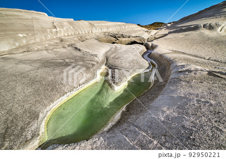 Unique white rocks on Sarakiniko beach and natural trapped water pool, Milos island, Greece. Empty cliffs, summer sunshine, clear blue sky 92950221